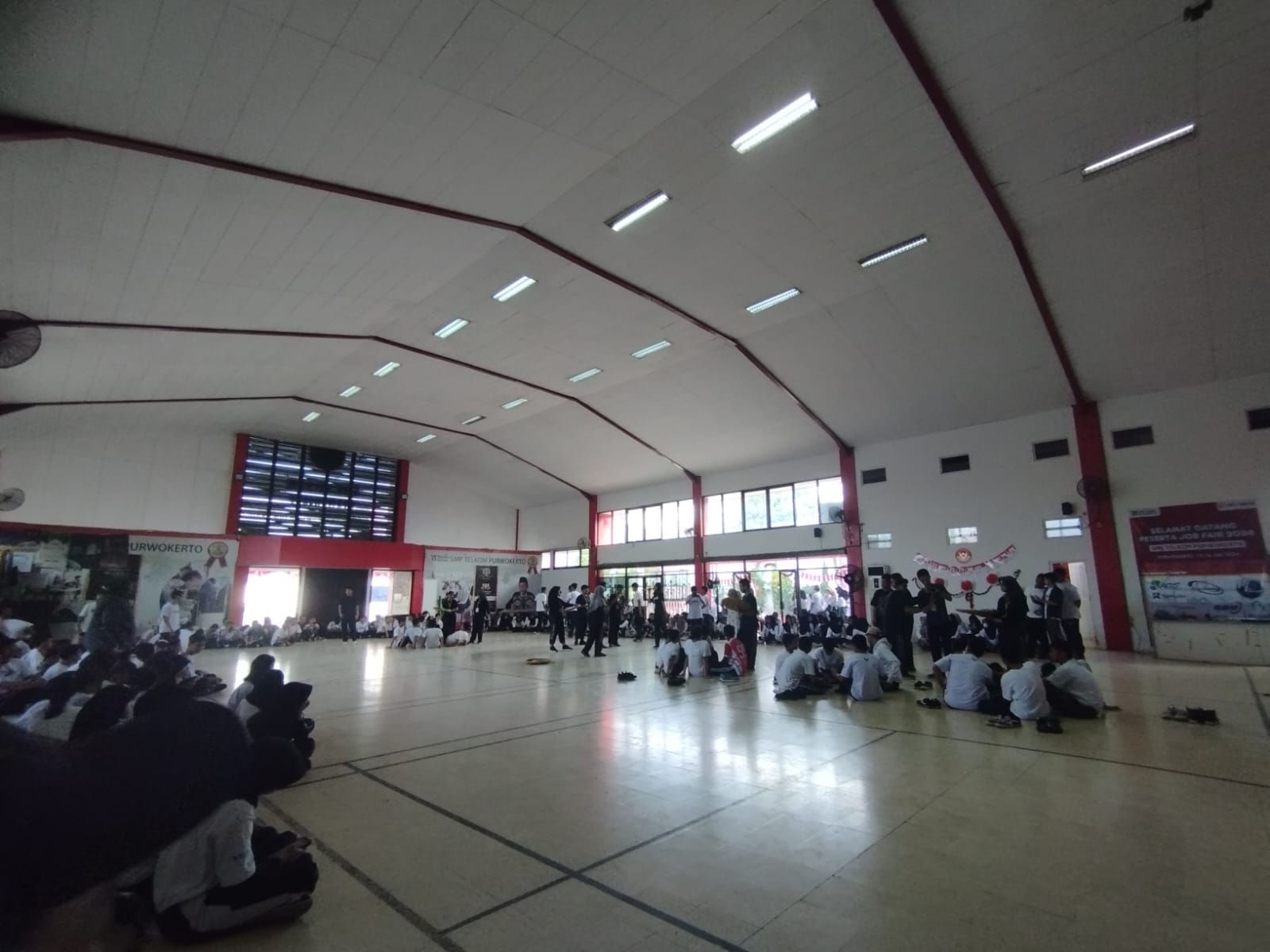Foto ini meceritakan siswa siswi SMK TELKOM PURWOKERTO yang sedang melaksanakan lomba memasukan bola di aula SMK TELKOM PURWOKERTO pada hari JUMAT,16/08/2024
